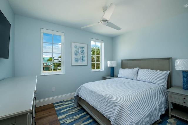 bedroom with dark wood-type flooring, baseboards, and ceiling fan