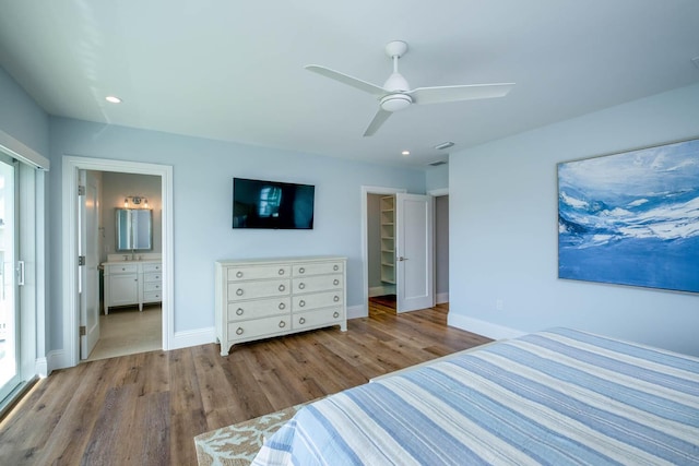 bedroom featuring a closet, wood finished floors, a spacious closet, baseboards, and recessed lighting