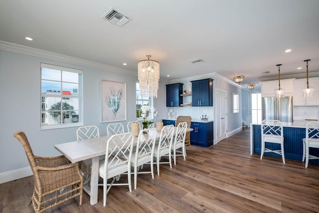 dining area featuring dark wood-type flooring, baseboards, visible vents, ornamental molding, and an inviting chandelier