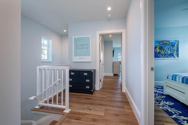 hall with baseboards, wood finished floors, and recessed lighting