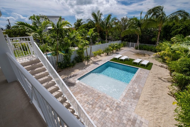 view of pool featuring a patio, a fenced in pool, a fenced backyard, and stairway