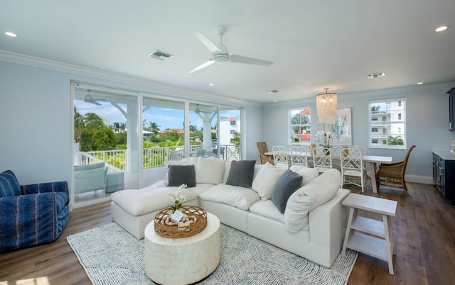 living room featuring a ceiling fan, ornamental molding, wood finished floors, and visible vents