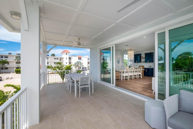 balcony with outdoor dining area and ceiling fan