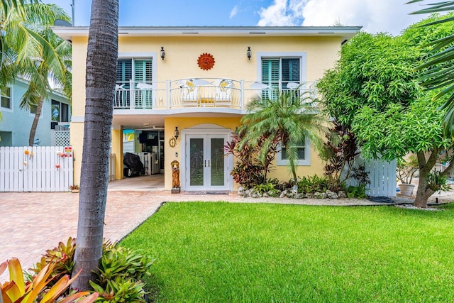 17 N Dr, Key Largo, FL 33037 - rear view of house featuring french doors, stucco siding, a yard, and a balcony