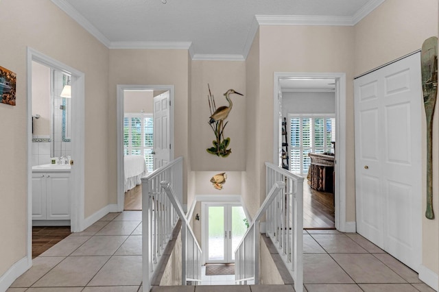 17 N Dr, Key Largo, FL 33037 - corridor featuring baseboards, ornamental molding, light tile patterned flooring, and an upstairs landing