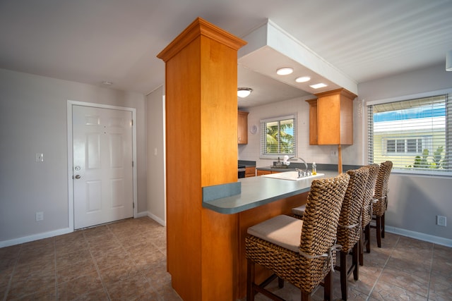 kitchen featuring sink, a breakfast bar area, and backsplash