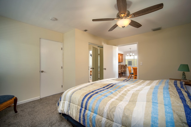 bedroom with ceiling fan with notable chandelier and carpet floors