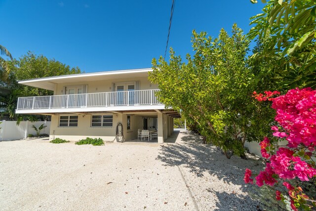 rear view of property featuring a patio and a balcony