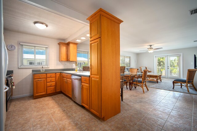 kitchen featuring ceiling fan, stainless steel dishwasher, and decorative backsplash