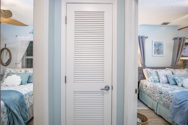 bedroom with a textured ceiling and light hardwood / wood-style flooring