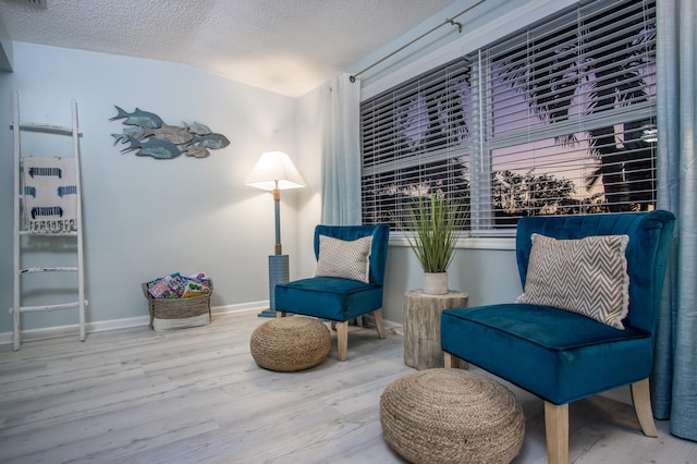 living area with hardwood / wood-style flooring and a textured ceiling