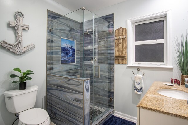 bathroom with vanity, toilet, and a shower with shower door