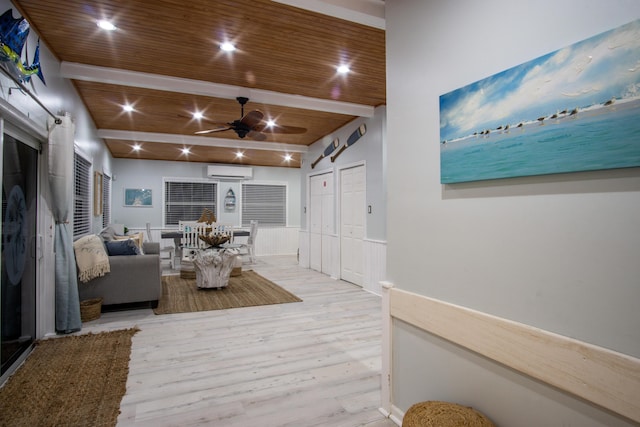 living room with a wall mounted AC, light wood-type flooring, wooden ceiling, ceiling fan, and beam ceiling