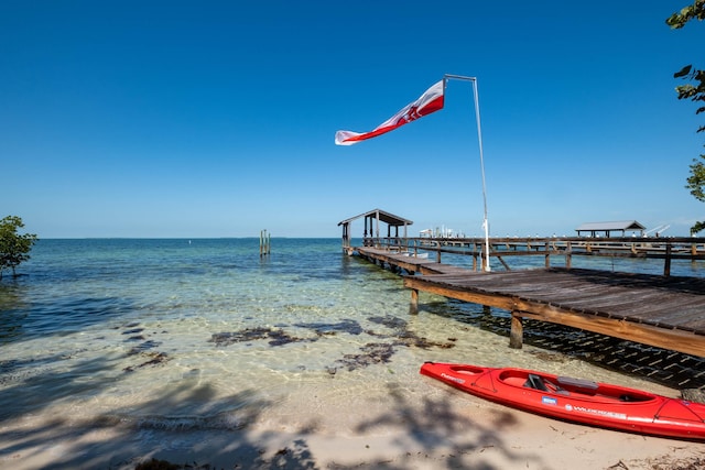 dock area with a water view and a view of the beach