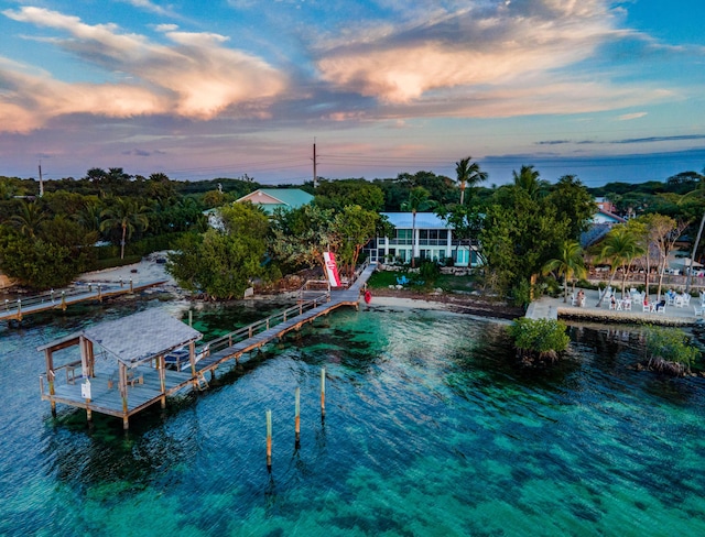 aerial view at dusk featuring a water view