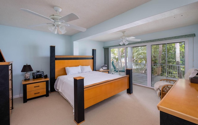 carpeted bedroom featuring multiple windows, access to exterior, and a textured ceiling