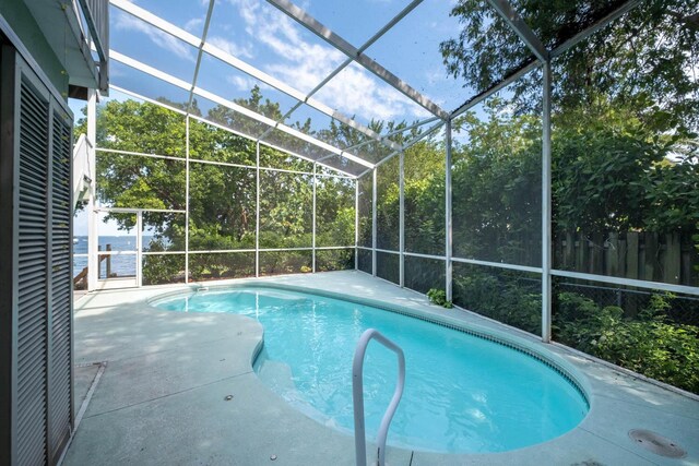 view of pool featuring a water view and a lanai