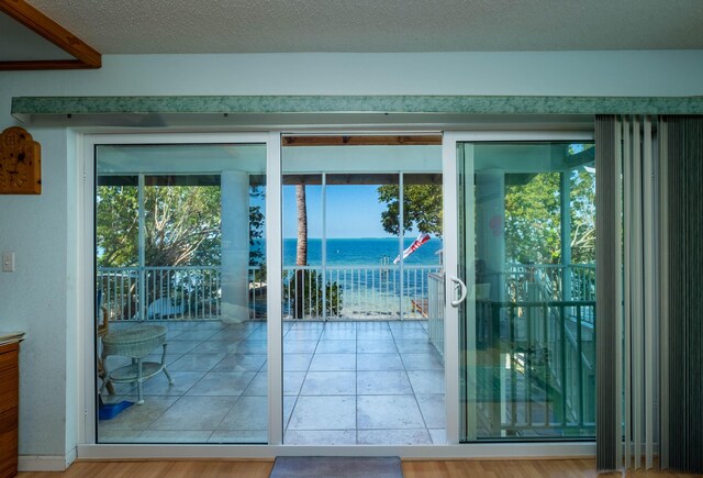 entryway featuring a water view and a textured ceiling