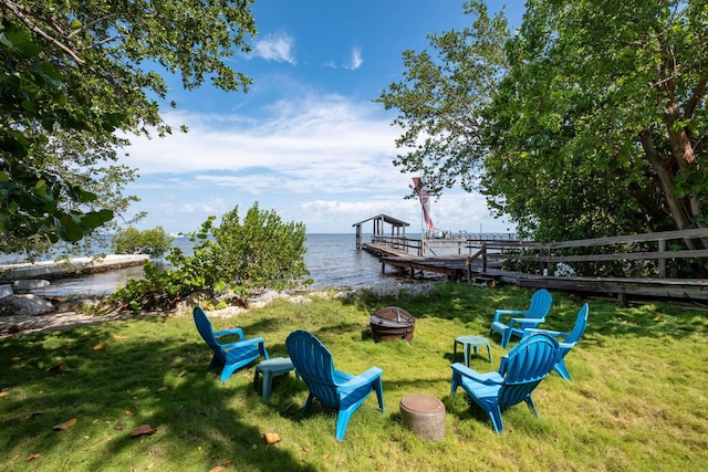 exterior space featuring a fire pit, a boat dock, and a water view