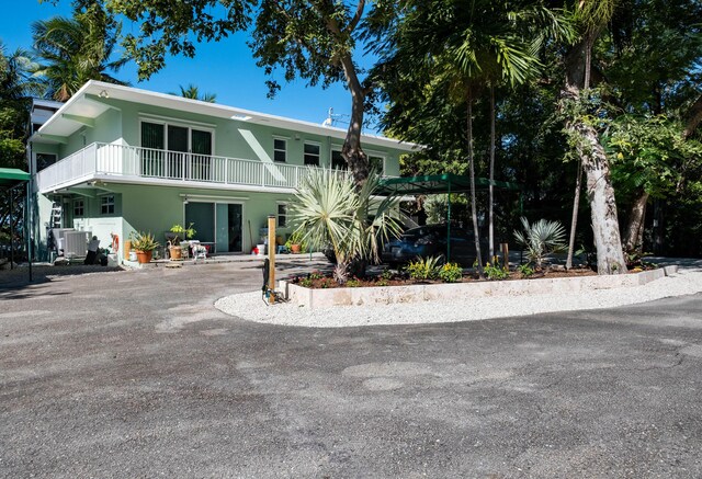 view of front of house featuring a balcony and central air condition unit