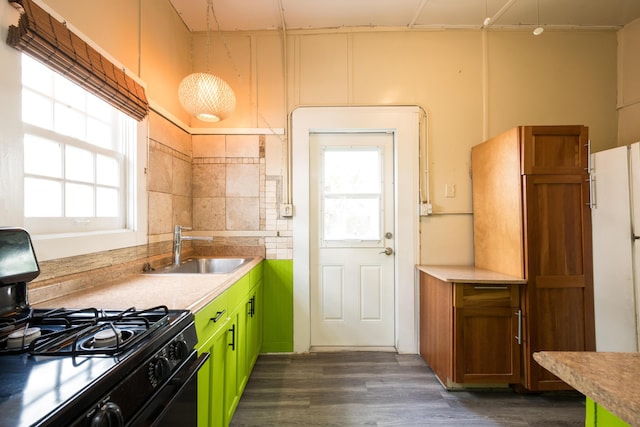 kitchen with a healthy amount of sunlight, black gas stove, sink, and dark wood-type flooring