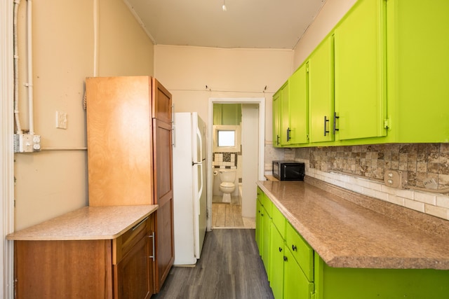 kitchen featuring white fridge, backsplash, dark hardwood / wood-style flooring, and green cabinetry