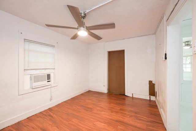 empty room with hardwood / wood-style floors, ceiling fan, and cooling unit