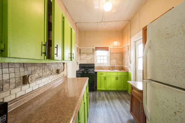 kitchen with sink, backsplash, white refrigerator, gas stove, and dark hardwood / wood-style flooring