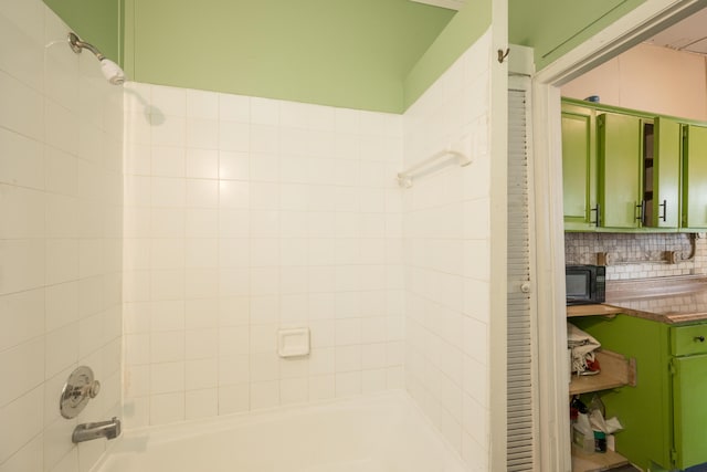 bathroom featuring backsplash and tiled shower / bath combo