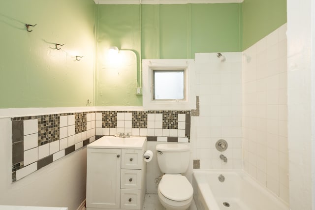 bathroom featuring vanity, toilet, tile walls, and a tub