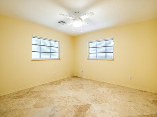 unfurnished room featuring a healthy amount of sunlight and ceiling fan