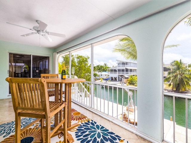 sunroom / solarium with a water view and ceiling fan