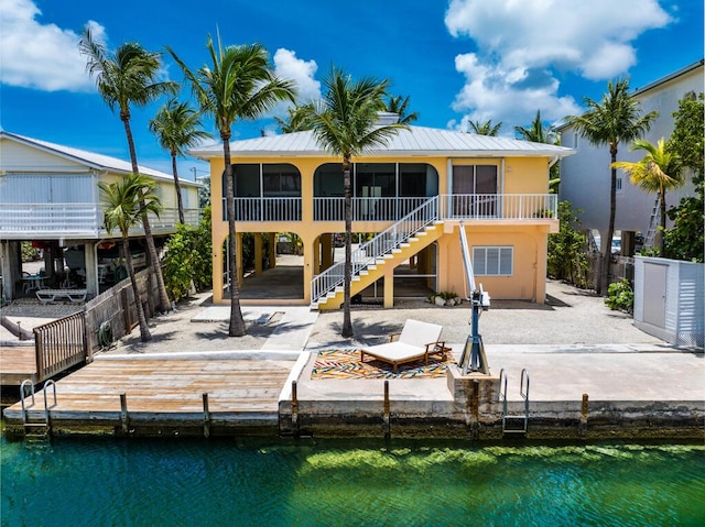 back of house featuring a water view and a sunroom