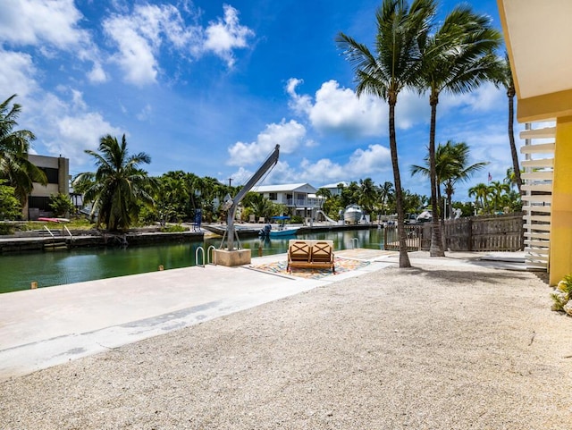 view of property's community featuring a patio, a boat dock, and a water view