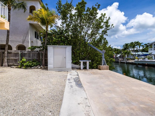 view of patio with a water view and a shed