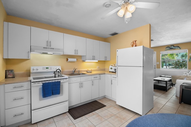 kitchen featuring under cabinet range hood, white appliances, light countertops, and a sink