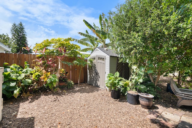 view of yard featuring a storage unit, an outbuilding, and a fenced backyard