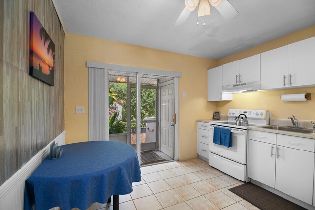 kitchen featuring electric range, white cabinets, under cabinet range hood, and a sink