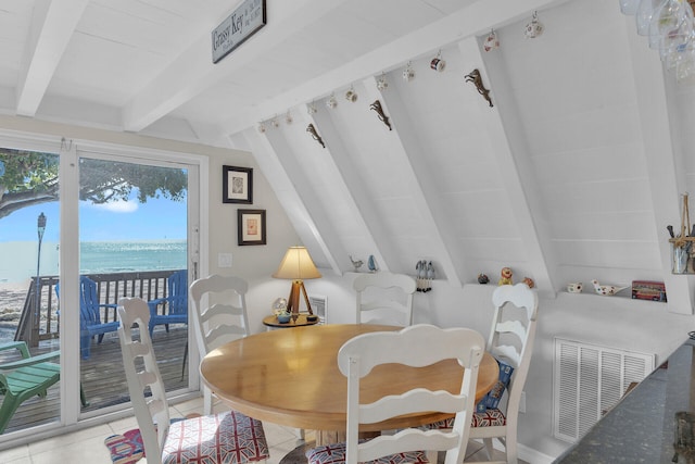 tiled dining area with lofted ceiling with beams and a water view