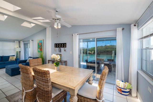 dining space featuring vaulted ceiling with skylight, ceiling fan, and light tile patterned floors