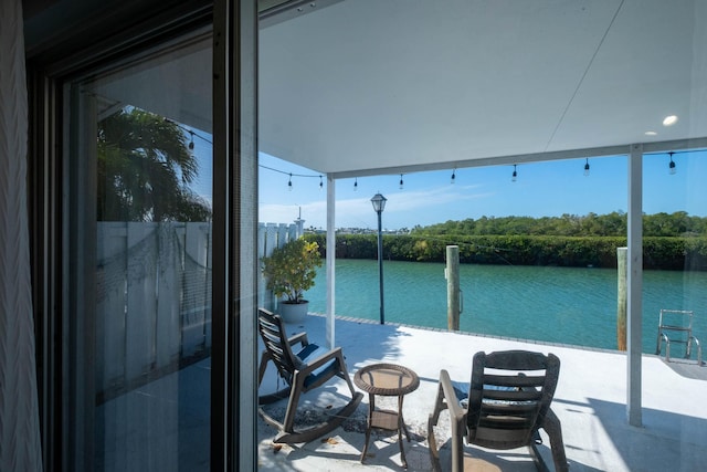 view of patio with a balcony and a water view