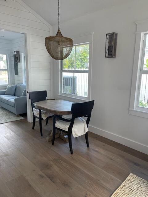 dining area featuring wood-type flooring, vaulted ceiling, and a wealth of natural light