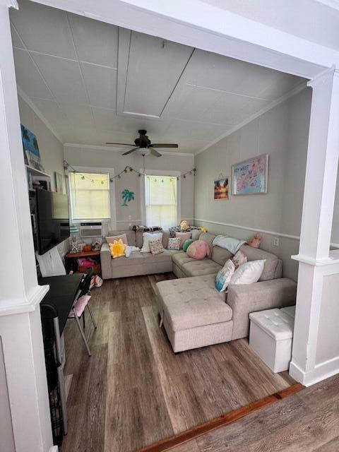 living room featuring hardwood / wood-style floors, ornamental molding, and ceiling fan