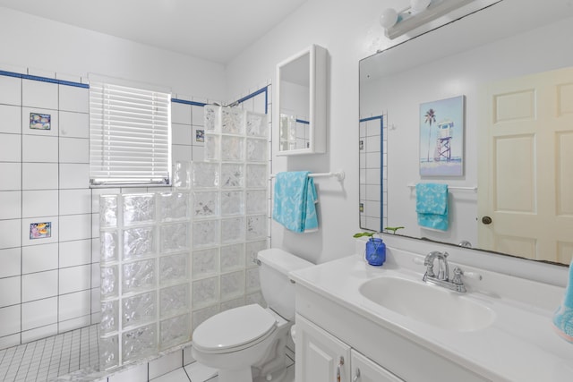 bathroom with vanity, toilet, and tiled shower