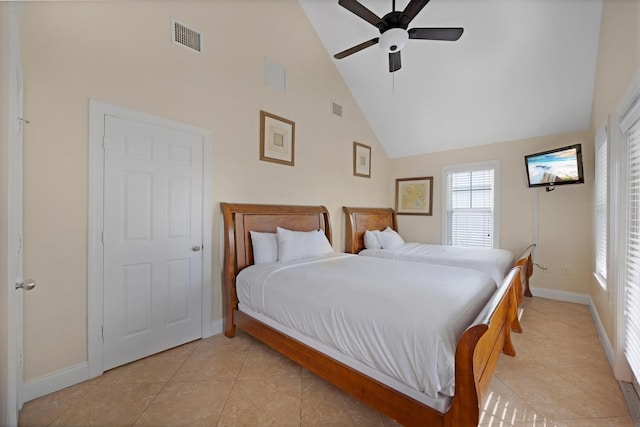 tiled bedroom with ceiling fan and high vaulted ceiling