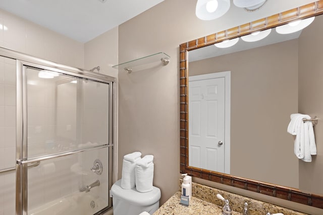 bathroom featuring bath / shower combo with glass door and toilet