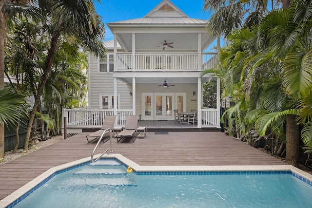 rear view of property featuring a balcony, a pool side deck, ceiling fan, and french doors