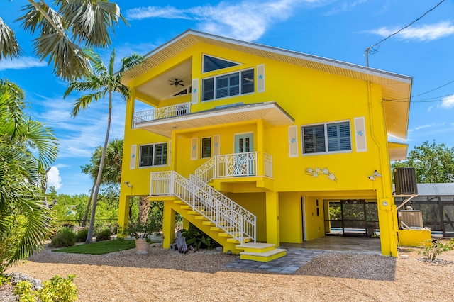 rear view of house featuring a carport, a balcony, and ceiling fan