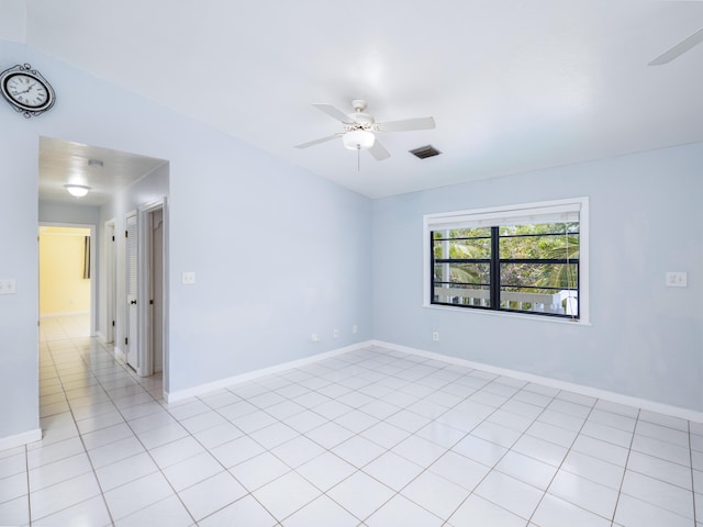 empty room with light tile patterned flooring, baseboards, and ceiling fan