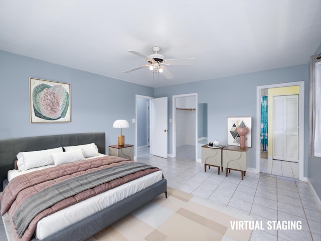 bedroom with baseboards, a spacious closet, light tile patterned flooring, and a ceiling fan